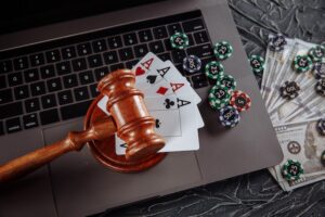 laptop with gavel, aces, money and poker chips
